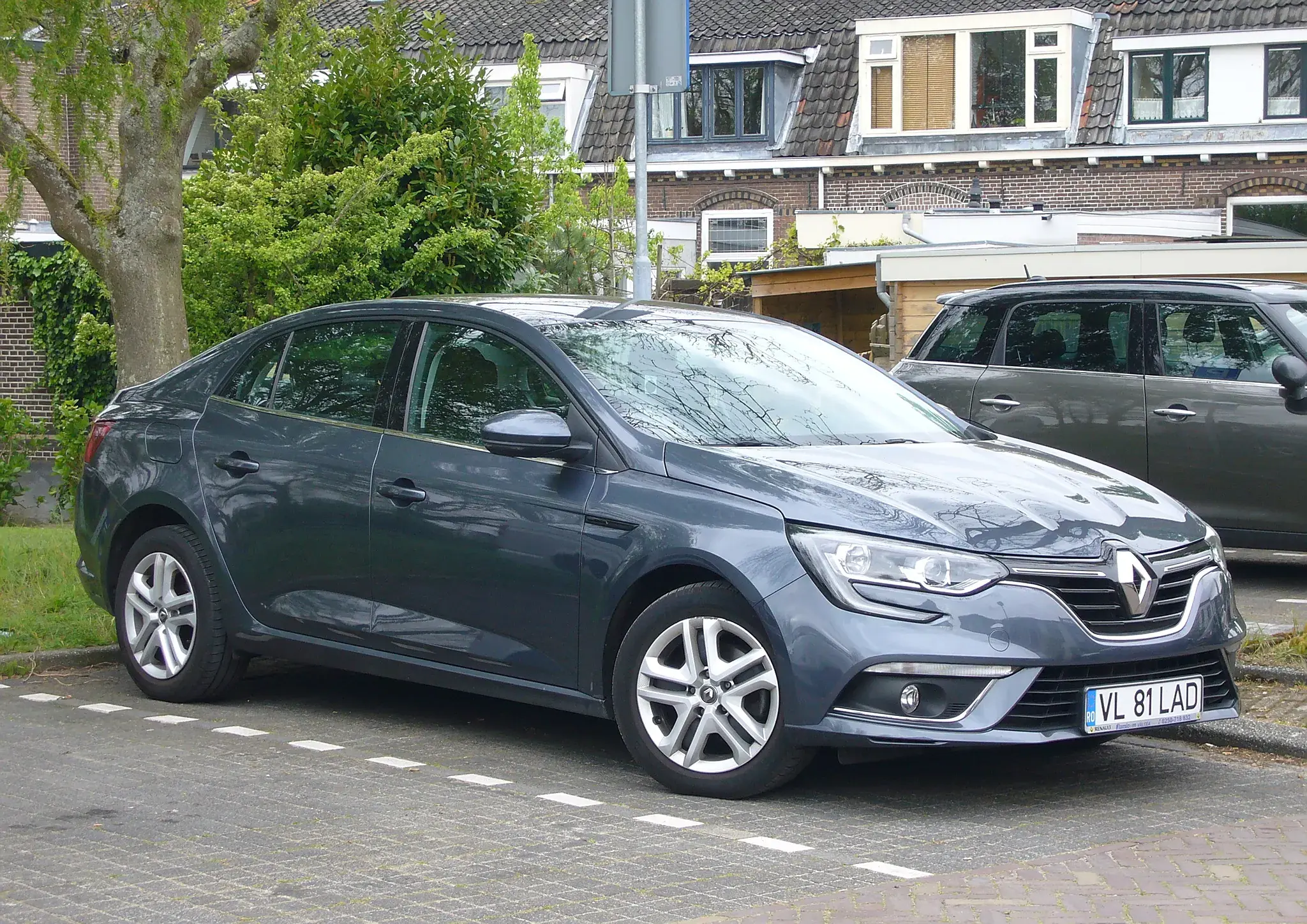 A grey Renault Mégane sedan parked on a street